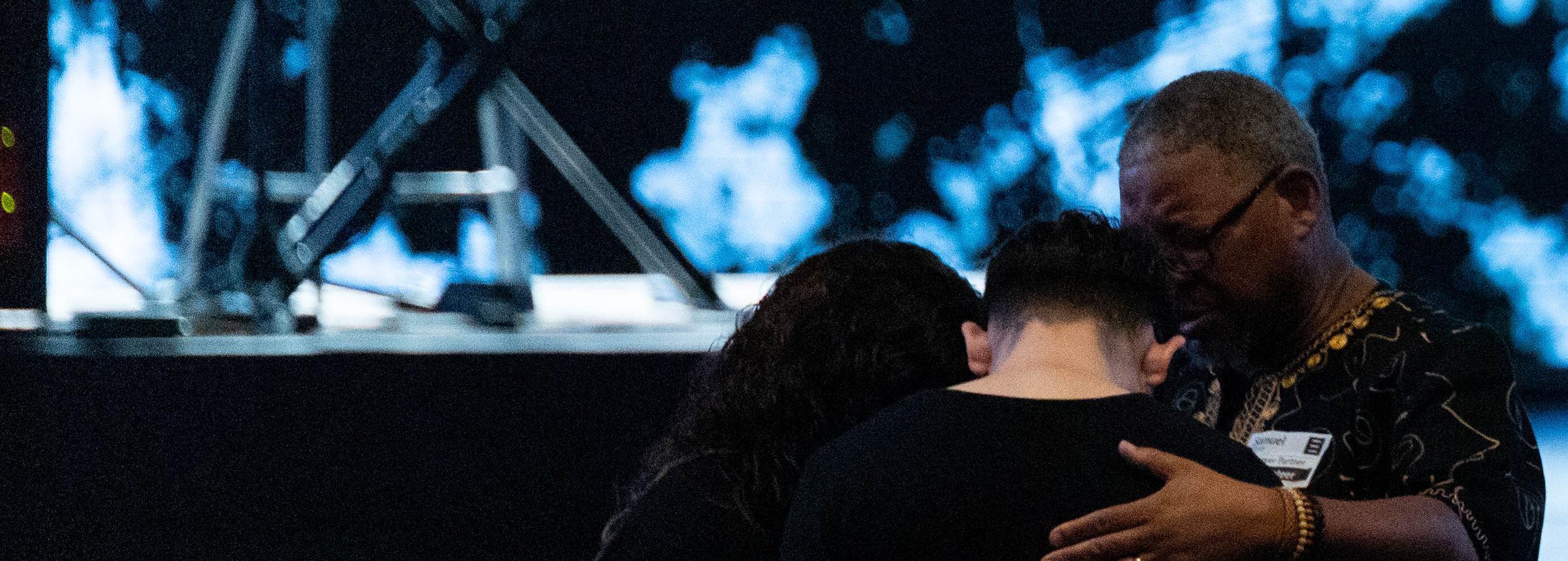 A pastor praying with a couple at the front of the Shoreline auditorium