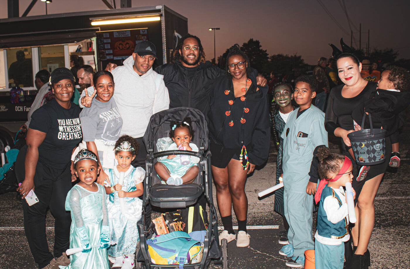A large family group in costume in front of the food truck