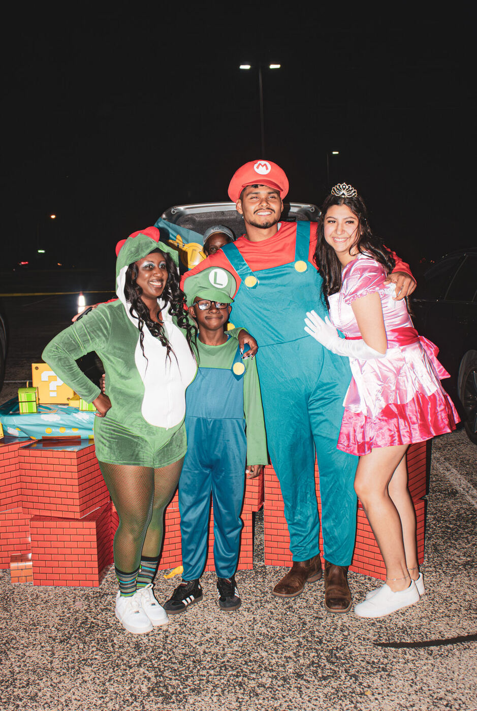 A family dressed as video game characters by their trunk
