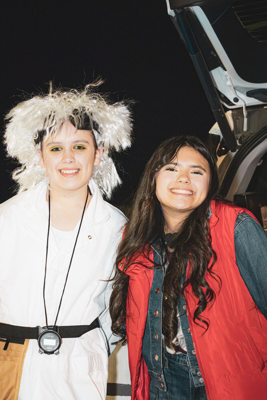 Two students in time-travel film costumes at a trunk